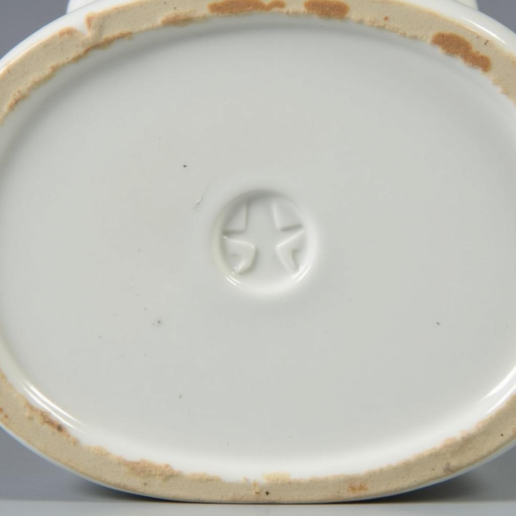 Antique porcelain bedpan with manufacturer's mark