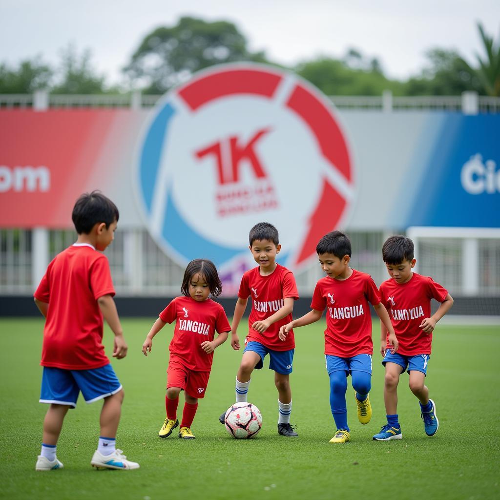 Young children practicing soccer with Đội Bóng Đá logo in the background